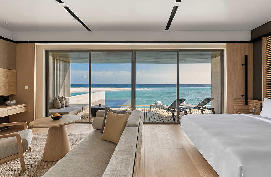 Luxury overwater villa bedroom with ocean-view terrace and modern interiors